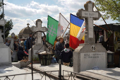 People queue up at a tomb bearing the flag with the insignia of the Iron Guard, in Bucharest