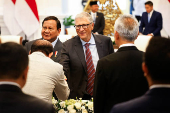 Bill Gates reacts next to Indonesian President Prabowo Subianto as he attends their meeting at the Merdeka Palace in Jakarta
