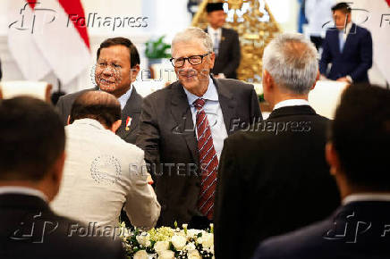 Bill Gates reacts next to Indonesian President Prabowo Subianto as he attends their meeting at the Merdeka Palace in Jakarta