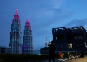A man takes photos of the Petronas Twin Tower in Kuala Lumpur