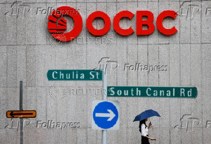 FILE PHOTO: People pass an OCBC Bank signage in Singapore