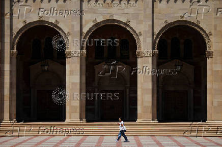A woman walks by Royce Hall at the University of California Los Angeles (UCLA) in Los Angeles