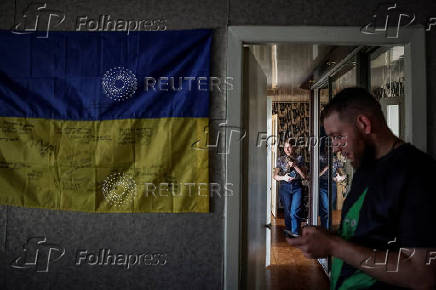 Ukrainian flag, signed by Ukrainian service members and their relatives, decorates the wall of a temporary apartment of former POW, in Zaporizhzhia
