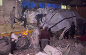 Palestinian workers unload an aid truck, in Khan Younis