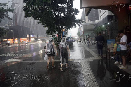 Pedestres enfrentam chuva e queda de temperatura em SP