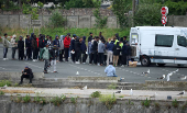 Migrants line up to collect food being distributed by a charity in Calais, France
