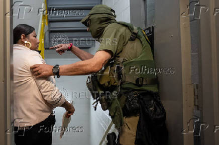 A migrant is detained by federal immigration officers at U.S. immigration court