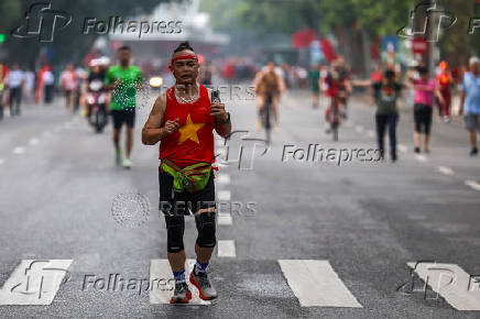 A man exercises along a road near Hoan Kiem Lake in Hanoi