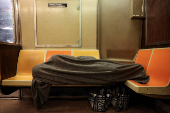A person sleeps in a subway in New York City