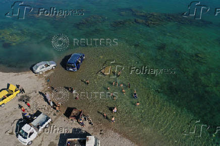 A drone view shows people enjoying in the Euphrates River during a hot day in Raqqa