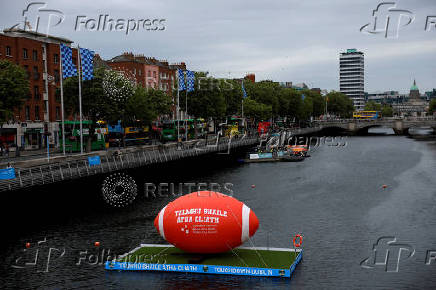 Giant American football floats on the river Liffey, in Dublin