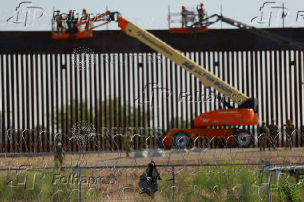U.S. soldiers reinforce border wall with razor wire seen from Ciudad Juarez