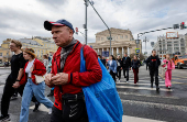 People cross the street in front of the Bolshoi Theatre in Moscow