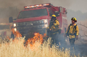 Firefighters battle flames at brushfire in Woodland California