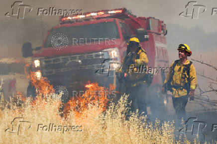 Firefighters battle flames at brushfire in Woodland California