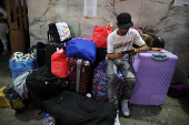 Migrants gather outside the Venezuelan embasssy waiting for a flight back to their country