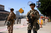 A U.S. Marine and a member of the National Guard stand guard outside the Edward R. Roybal Federal Building, in Los Angeles