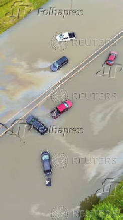 A drone view shows partially submerged vehicles on a flooded road in Milwaukee