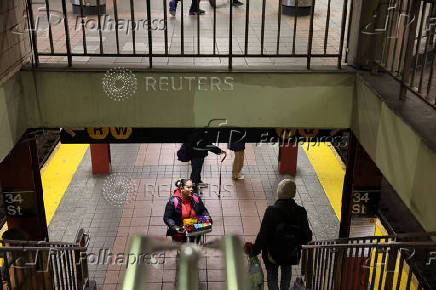 A woman sells candy on a subway platform in New York City
