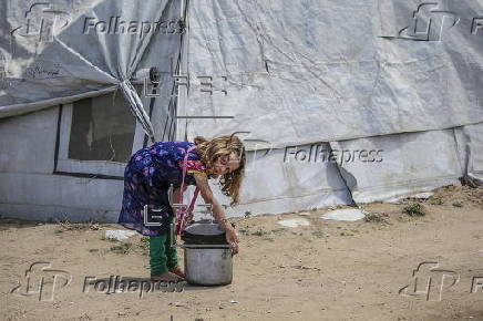 Displaced Palestinians collect donated food in Jabalia, northern Gaza