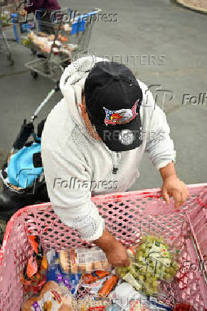 A man unpacks a grocery cart of prepared food outside Adams County Emergency Food Bank, weeks into the continuing U.S. government shutdown, in Commerce City