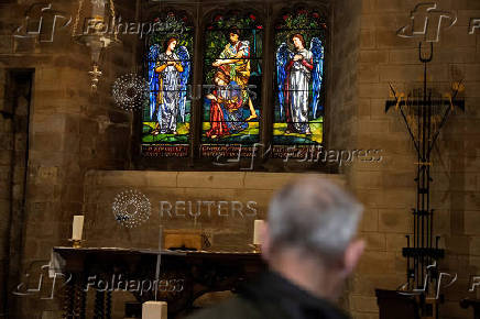 A visitor stands inside the Harvard Chapel at Southwark Cathedral in London