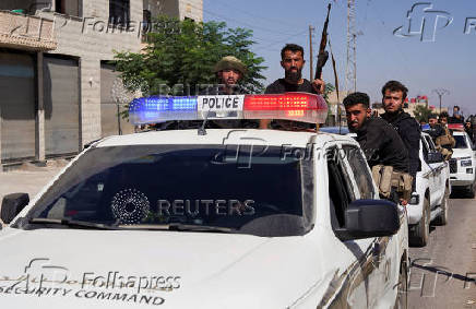 Members of Syrian security forces sit at a back of a vehicle after Syrian troops entered the predominantly Druze city of Sweida