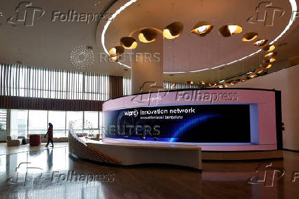 A woman walks past a screen inside the innovation lab at Wipro's premises in Bengaluru