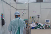 Funcionário atende paciente no hospital de campanha do Ibirapuera