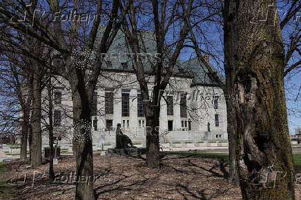 A person walks with a dog outside the Supreme Court of Canada in Ottawa