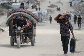 Palestinians make their way with belongings as they flee their homes