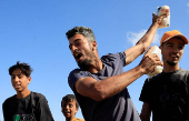 Palestinians seeking aid gather near an aid distribution site run by the U.S.-backed Gaza Humanitarian Foundation, in Rafah
