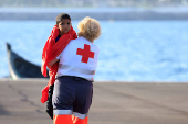 A migrant minor is transferred by the Red Cross after disembarking from a Spanish coast guard vessel, in the port of Arguineguin