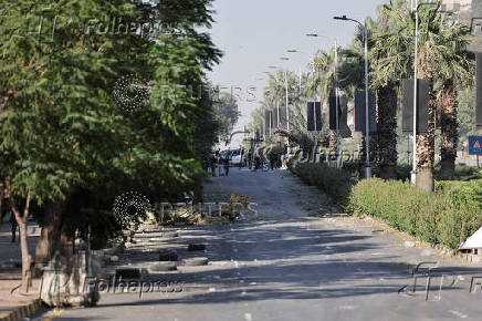 People gather near a damaged site, in Damascus