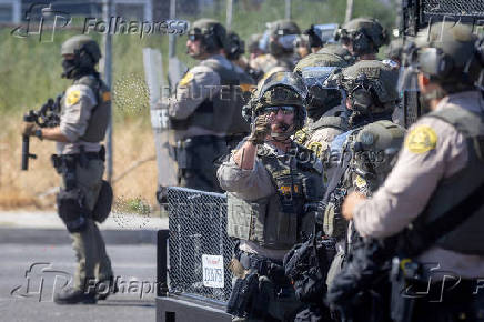 Los Angeles County Sheriff's deputies assemble during a standoff with protesters in Compton