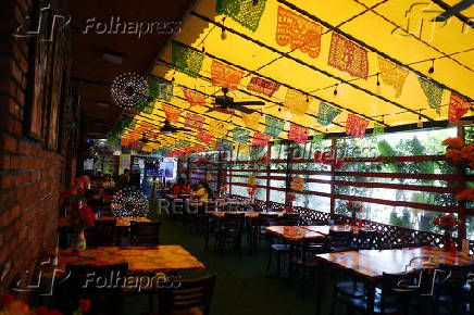 People eat at a Mexican restaurant partially empty, in Los Angeles