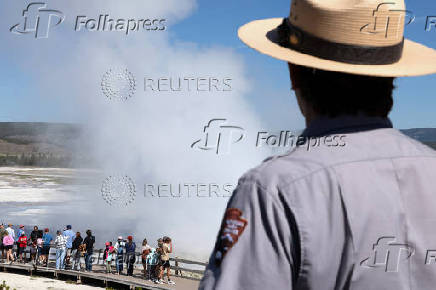 National Park Service Seasonal Interpretation Ranger Denine Northup watches as three geysers erupt simultaneously during her program at the Fountain Paint Pot geothermal area in Yellowstone National Park