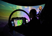 A member of BAE Systems staff demonstrates a new and improved cockpit display for the companies Typhoon military jets in an aircraft simulator at their Warton factory in Warton