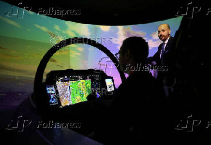 A member of BAE Systems staff demonstrates a new and improved cockpit display for the companies Typhoon military jets in an aircraft simulator at their Warton factory in Warton