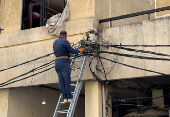 A man works with electricity cables at a damaged site in the aftermath of Israeli strikes, in Beirut's southern suburbs