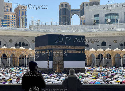 Policeman looks as Muslims perform the farewell Tawaf ritual around the Kaaba at the Grand Mosque in the holy city of Mecca