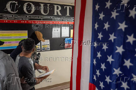 A migrant is detained by federal immigration officers at U.S. immigration court
