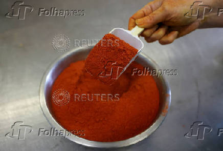 A staff member scoops chilli powder at Spice Kitchen, as the company reacts to U.S President Donald Trump's tariffs, in Liverpool