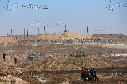 Palestinians carry aid supplies which they received from the U.S.-backed Gaza Humanitarian Foundation