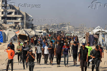 Palestinians gather as they wait for aid supplies to enter Gaza