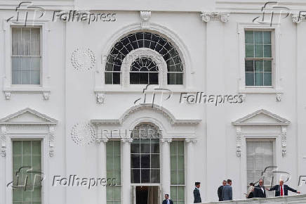 U.S. President Trump talks with architect McCrery as they walk on the roof of the White House in Washington