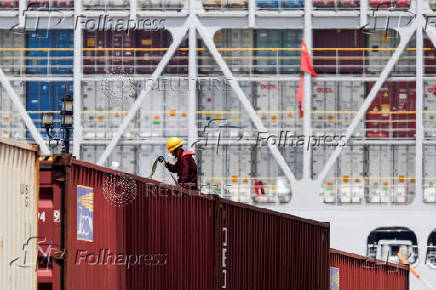 FILE PHOTO: A crew member works on a container ship which is docked at Yangshan Port outside of Shanghai