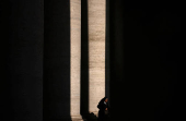 A nun walks under the Bernini Colonnade surrounding St. Peter's Square ahead of the conclave, which will be held on May 7