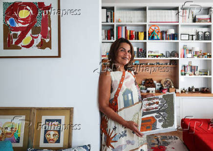 Daniela Falcão posa com obra em casa durante entrevista