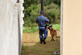 Police officers inspect the scene where kidnapped U.S. pastor, Josh Sullivan, was rescued last night in a shootout during which three suspects were killed, in KwaMagxaki